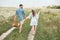 rear view of couple with picnic basket holding hands while walking