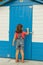 Rear view curious girl knocking on a striped door