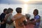 Rear view of diverse senior adult standing together at the beach