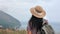 Rear view elegant woman traveler with backpack walking on mountain peak admiring nature landscape