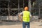 Rear view of engineer or contractor standing at a building site. Young businessman construction site engineer