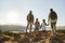 Rear View Of Family Standing At Top Of Hill On Hike Through Countryside In Lake District UK