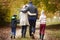 Rear View Of Family Walking Along Autumn Path