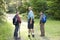 Rear view father and sons hiking in woods on trail