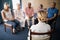 Rear view of female doctor meditating with senior people