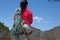 Rear view female hiker with hank of rope standing on mountain