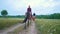 Rear view of female riders on horseback passing by the path