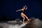 Rear view female wakesurfer riding on the wakesurf in the night