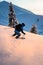 rear view of freerider sliding down snow-covered slopes on fresh powder snow