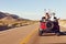 Rear View Of Friends On Road Trip Driving In Convertible Car