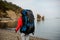 Rear view girl in sportwear walking near the sea with hiking backpack