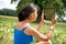 Rear view of girl using a tablet sitting on meadow