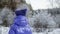 Rear view of girl walking in snow-covered forest at wintertime
