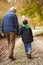 Rear View Of Grandfather And Grandson Walking Along Path