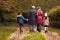 Rear View Of Grandparents Holding Hands With Grandchildren On Walk Through Autumn Countryside