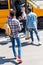 rear view of group of teen scholars walking to school bus