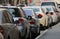 Rear view of groups cars in street parking. Visible headlights, side mirrors, rear windows and tires