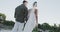 Rear view of happy diverse bride and groom walking holding hands at beach wedding, in slow motion