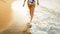 Rear view image of beautiful sexy barefoot woman in bikini walking in calm sea waves on the beach towards the sunset