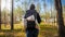 Rear view image of heavy big backpack on female tourist back walking in forest