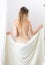 Rear view image of young woman wiping body with towel after having bath