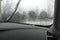 Rear view from inside mirror car, window windshield glass covered with frozen ice layer, nature background at winter