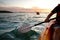 Rear view of kayaker man paddle kayak at sunset sea. Kayaking, canoeing, paddling
