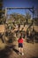 Rear view of kid looking at outdoor equipment during obstacle course