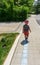 Rear view of a little boy walking by himself on the sidewalk of a residential area