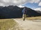 Rear view of lone asian hiker walking on dirt road