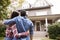 Rear View Of Loving Couple Looking At House