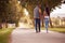 Rear View Of Loving Couple Walking Hand In Hand Along Track Through Countryside