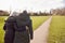 Rear View Of Loving Senior Couple Enjoying Autumn Or Winter Walk Through Park Together