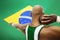 Rear view of male shot putter aiming against Brazilian flag