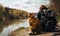 Rear view of a man with backpack on shoulders sitting near the river. Big fluffy cat resting beside the owner. Nature backdrop in