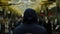 Rear view of a man with a dark blue hoodie on standing in front of a crowd at the station, resistance concept. Close up