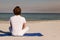 Rear view of man meditating at beach