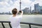 Rear view of man photographing Oriental Pearl Tower while standing by railing