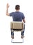 Rear view of a man sitting on a chair and raising a hand to ask a question