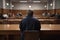 Rear view of a man sitting in front of a group of people in the conference hall, A court attorney lawyer full rear view inside