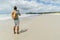 rear view of man taking photo of coastline with smartphone Rarawa beach