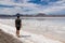 Rear view of man walking along lakeshore with beautiful mountains reflecting in lake of Bonneville Salt Flats, Wendover, Western