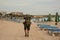 Rear view man walking with a hiking backpack on the sea coast