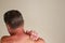 Rear View of Mature Caucasian Male Massaging His Right Naked Shoulder