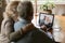 Rear view mature couple making video call to relatives