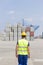 Rear view of mid adult worker walking in shipping yard