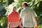 Rear View Of Middle Aged Couple Walking Along Country Lane