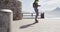 Rear view of mixed race woman skateboarding on sunny promenade by the sea