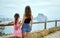 Rear view mother hug daughter family traveling around Spain admiring view of Penyal d`Ifac Natural Park of Calpe