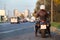 Rear view at motorcyclist with bike standing on urban road, female rider is ready to start movement in city